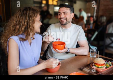 Junges Paar, das in einem Restaurant gesundes Essen isst Stockfoto