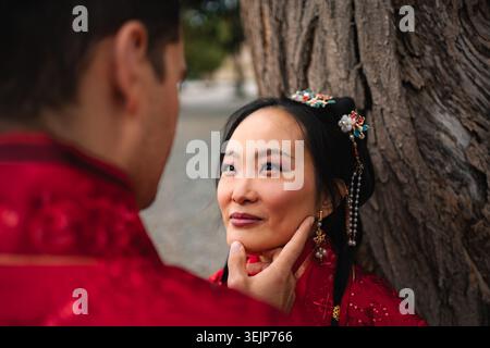 Gemischtes Paar, das traditionelle chinesische Hochzeitszeremonie feiert Stockfoto
