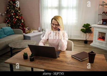 In einem gemütlichen Home-Office, das für die Feiertage eingerichtet ist, können Sie sich lebhaft unterhalten Stockfoto