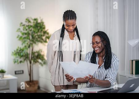 Afroamerikanische Frauen, die im Home Office an Geschäftsdokumenten arbeiten Stockfoto
