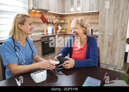 Freundliche Gesundheitsinteraktion in einer gemütlichen Küche während einer Check-up Stockfoto