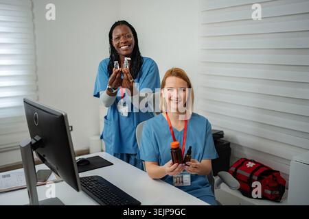Medizinische Fachkräfte, die Medizin und Fläschchen in der Klinik präsentieren Stockfoto