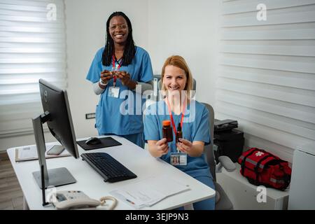 Medizinische Fachkräfte zeigen Medikamente und Ergänzungsflaschen im Büro Stockfoto