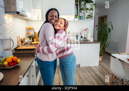 Mutter und Tochter, die sich in der modernen Küche lieben Stockfoto