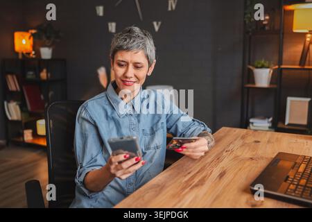 Frau, die online mit Kreditkarte und Smartphone bezahlt Stockfoto