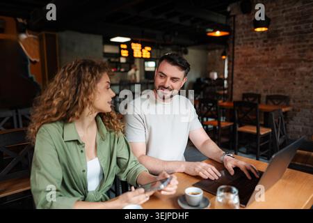 Junge Unternehmer, die in einem Café an einem Laptop arbeiten Stockfoto