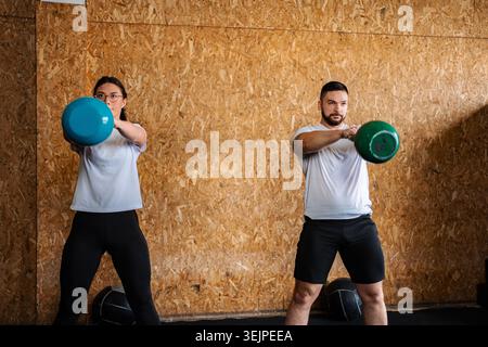 Menschen, die in einem Fitnessstudio mit Kettlebells trainieren Stockfoto