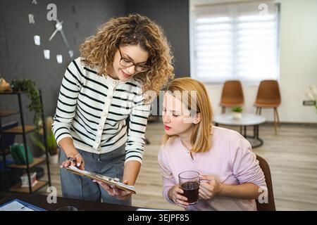 Zwei weibliche Kollegen arbeiten zusammen an einem Geschäftsbericht Stockfoto