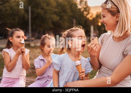 Glückliche Familie, die einen Sommertag mit Eis im Freien genießt Stockfoto