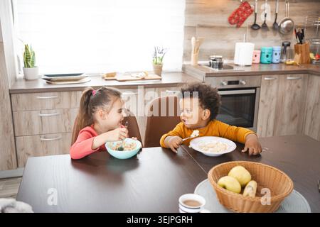 Die multirassische Familie genießt das gemeinsame Frühstück in gemütlicher Küche Stockfoto