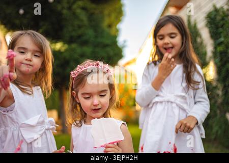 Drei Mädchen, die einen bunten Tag im Garten genießen Stockfoto