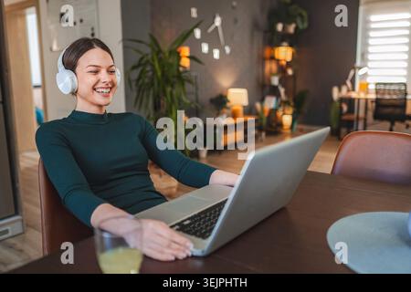 Junge Frau, die von zu Hause aus arbeitet und einen Videoanruf hat Stockfoto