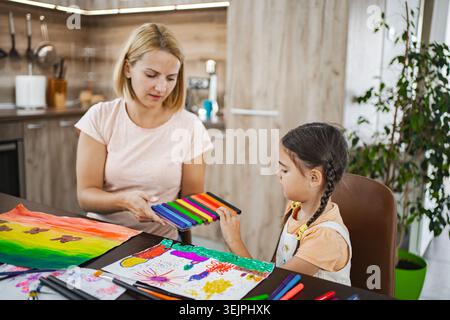 Mutter und Tochter arbeiten zu Hause an kreativer Kunst Stockfoto