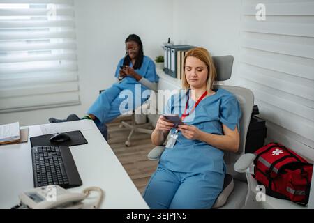 Pfleger am Pausenauszug SMS auf Handys in der Klinik Stockfoto