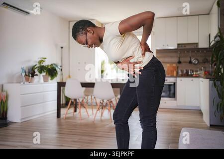 Junge Frau mit starken Bauchschmerzen zu Hause Stockfoto