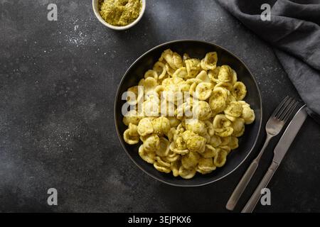 Nudelorecchiette mit Soße-Pesto auf schwarzem Hintergrund. Stockfoto