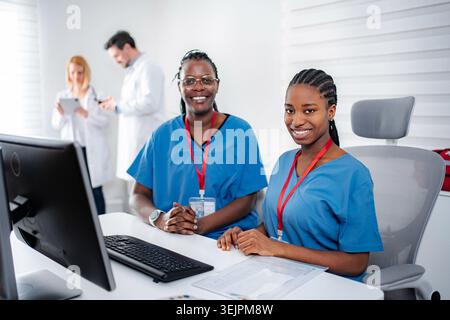 Vielfältiges medizinisches Personal, das an der Rezeption des Krankenhauses arbeitet Stockfoto