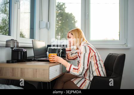 Gestresste Frau, die von zu Hause aus arbeitet und schwere Kopfschmerzen hat Stockfoto