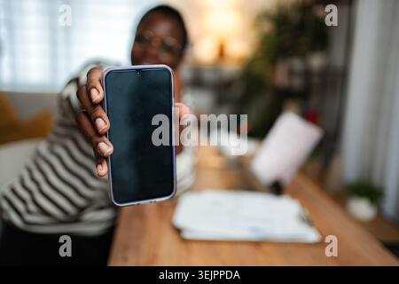 Person, die das Smartphone hält, zeigt einen leeren dunklen Bildschirm an Stockfoto