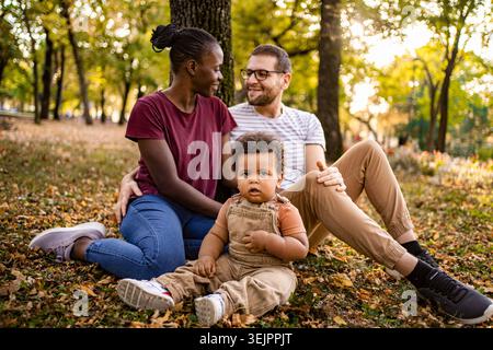Die Familie genießt mit ihrem Kind einen lebhaften Herbsttag im Park Stockfoto