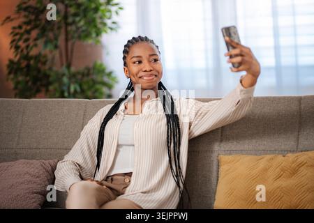 Junge Frau, die zu Hause Selfie mit Smartphone macht Stockfoto