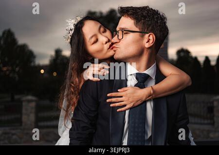 Interrassische Brautpaare küssen Liebe und Vielfalt Stockfoto
