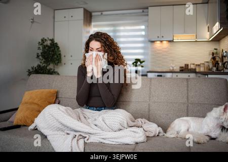 Frau, die die Nase in das Gewebe bläst und an Allergie leidet Stockfoto