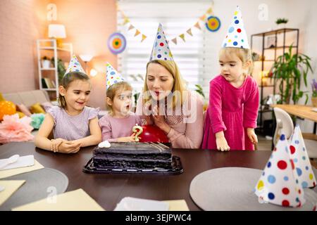 Wir feiern eine fröhliche Geburtstagsparty mit Familie und Kuchen Stockfoto