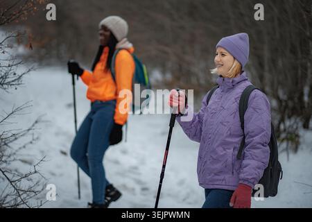 Frauen, die im Winter auf einem verschneiten Bergpfad wandern Stockfoto