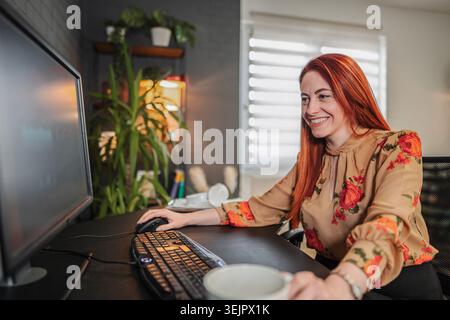 Junge Geschäftsfrau, die von zu Hause aus arbeitet, eine Kaffeepause macht Stockfoto
