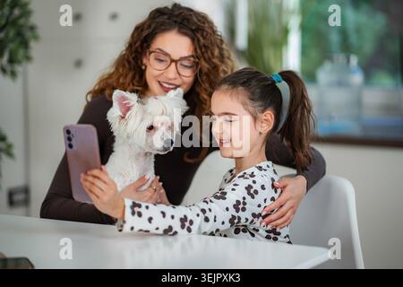 Mutter und Tochter machen Selfie mit dem Hund der Familie Stockfoto