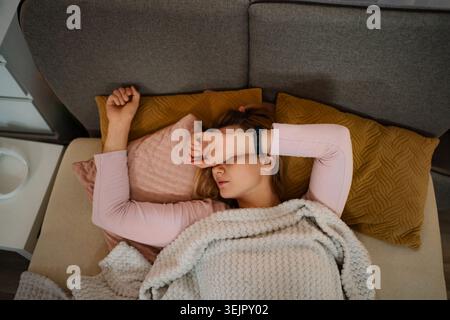 Frau, die auf dem Sofa schläft, fühlt sich müde und gestresst Stockfoto