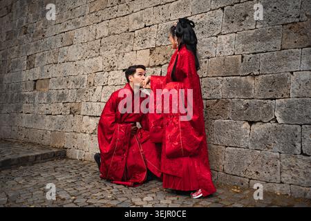 Interkulturelles Paar, das in traditioneller chinesischer Kleidung Hochzeit feiert Stockfoto