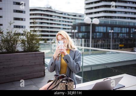 Junge Frau, die Fotos mit dem Smartphone auf der Stadterrasse macht Stockfoto