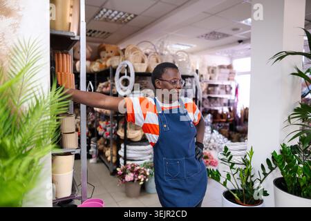 Selbstbewusste Floristin macht eine Pause in ihrem Blumenladen Stockfoto