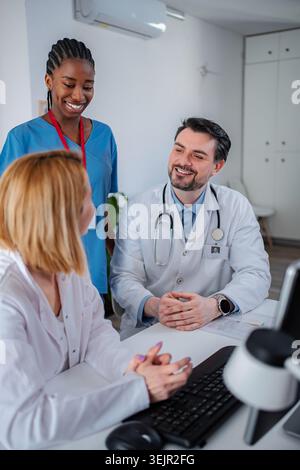 Vielfältiges medizinisches Team, das im Klinikbüro des Gesundheitswesens zusammenarbeitet Stockfoto