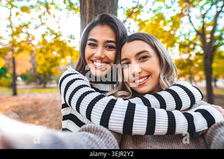 Zwei Frauen, die sich in einem Park umarmen Stockfoto