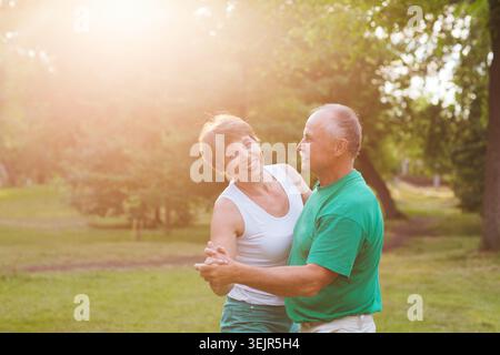 Seniorenpaar tanzt am sonnigen Tag im Park Stockfoto