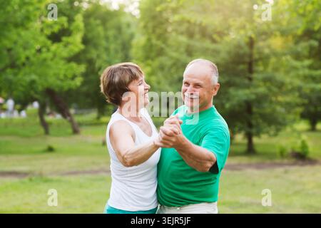Seniorenpaar tanzt am sonnigen Tag im Park Stockfoto