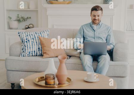 Junge Freiberuflerin, die an einem Projekt mit einem Notizbuch auf der Couch arbeitet Stockfoto
