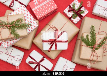 Weihnachtsgeschenkbox mit Zierpapier und dekorativem rotem Seidenband. Stockfoto