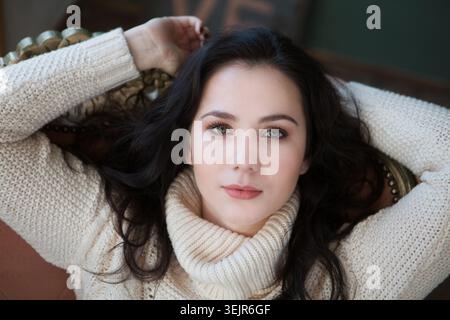 Porträt der schönen jungen Frau, die am Fenster lächelt Stockfoto