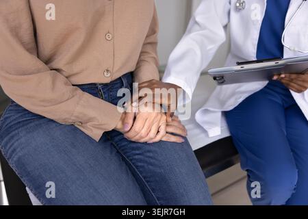 Junge Ärztin, die Seniorinnen unterstützt, motiviert, tröstet Stockfoto