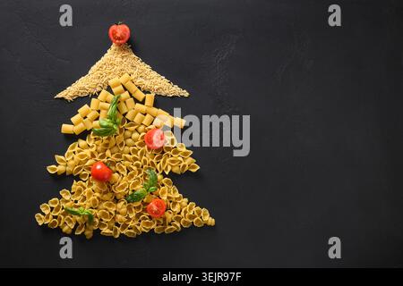 Weihnachtsbaum mit rohen Pasta dekorierten Tomaten, Basilikumblättern. Weihnachtskarte. Stockfoto