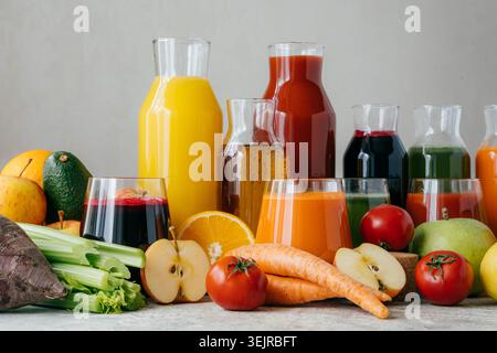 Frische Frucht- und Gemüsesäfte in Glasflaschen mit gesunden Produkten auf Küchentisch Stockfoto