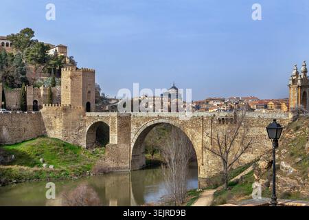 Puente de Alcantara römische Bogenbrücke über den Fluss Tejo in Toledo, Spanien. Historische Steinbefestigung bei hellem Tageslicht Stockfoto