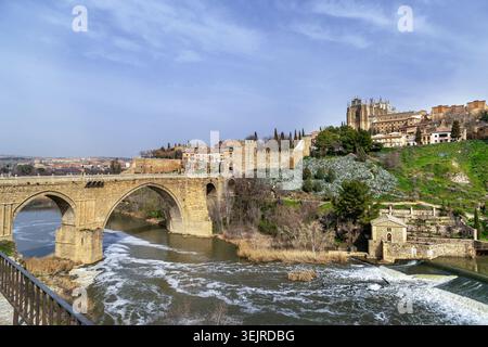 Kloster San Juan de los Reyes und Brücke über den Fluss Tejo in Toledo, Spanien. Mittelalterliche Steinarchitektur bei Tageslicht Stockfoto