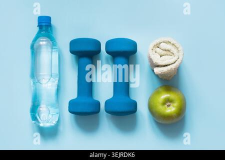 Sportausrüstung. Kreative flache Lage von Sport- und Fitnessgeräten auf Blau mit Kopierraum. Stockfoto