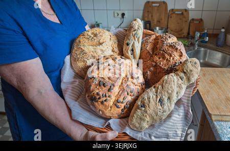 Hamburg, Deutschland. 31. Mai 2026. Eine Frau zeigt selbstgebackenes Brot in ihrer Küche. Quelle: Markus Scholz/dpa/Alamy Live News Stockfoto