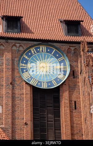 Torun, Polen - 27. Juni 2020: Dekorative Uhr auf roter Backsteinfassade der gotischen Kathedrale von Torun aus dem 13. Jahrhundert Stockfoto
